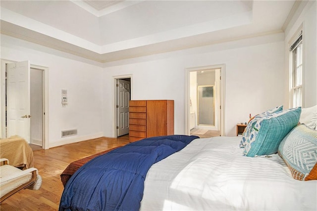 80 Stratford Pl NE, Atlanta, GA 30342 - bedroom featuring wood finished floors, a raised ceiling, crown molding, and connected bathroom