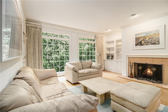 80 Stratford Pl NE, Atlanta, GA 30342 - living room with crown molding, light wood-style flooring, a tile fireplace, and built in shelves