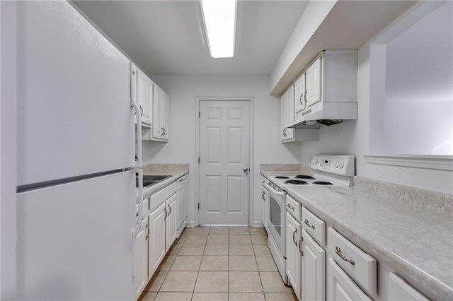 kitchen featuring white cabinetry, light tile patterned flooring, and white appliances