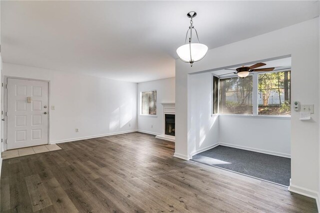 unfurnished living room featuring dark hardwood / wood-style floors and ceiling fan