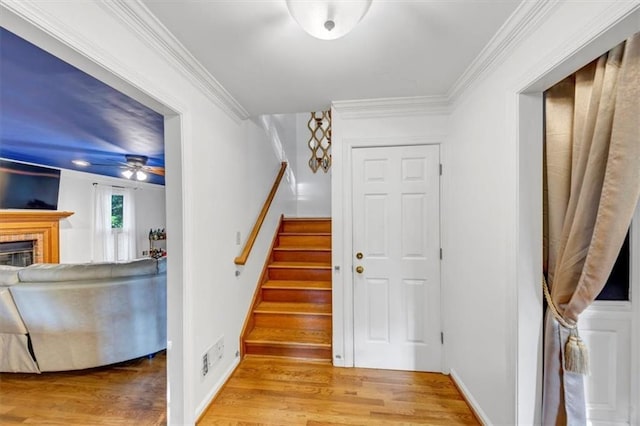 4817 Overland Dr, Powder Springs, GA 30127 - stairway featuring wood finished floors, ceiling fan, ornamental molding, and a glass covered fireplace