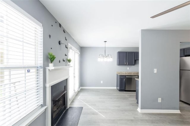 6726 Gallant Ct SE Unit 30, Mableton, GA 30126 - kitchen with appliances with stainless steel finishes, a fireplace with flush hearth, light wood-style floors, a chandelier, and light countertops