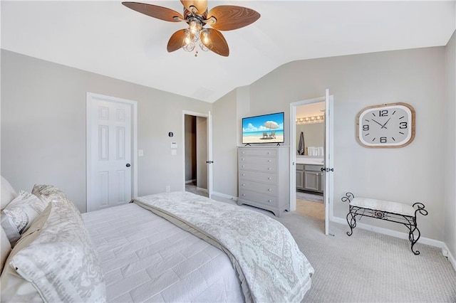 bedroom featuring a ceiling fan, vaulted ceiling, baseboards, ensuite bathroom, and light carpet