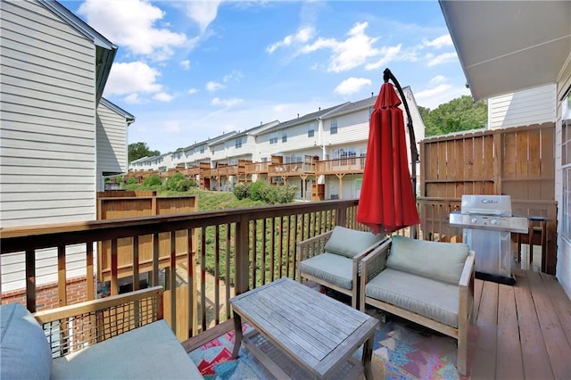 wooden terrace with an outdoor hangout area, grilling area, and a residential view