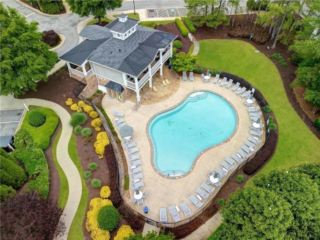 community pool with a patio and fence