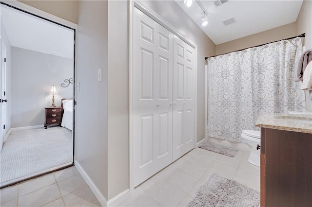 bathroom featuring a shower with curtain, tile patterned flooring, vanity, baseboards, and toilet