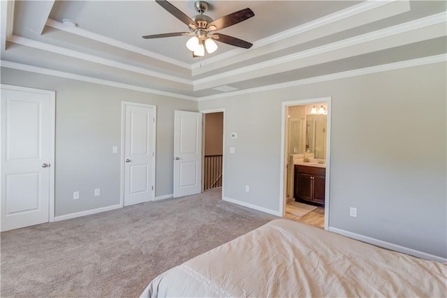 unfurnished bedroom featuring connected bathroom, crown molding, baseboards, carpet floors, and a raised ceiling