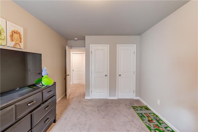 bedroom with baseboards and light carpet