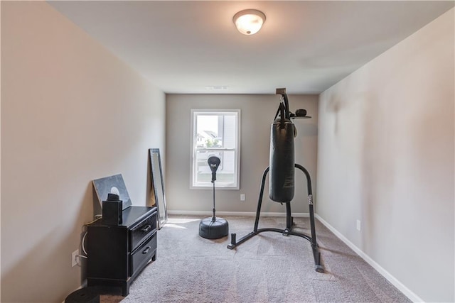 exercise room featuring baseboards and carpet