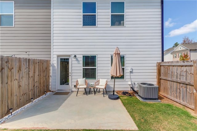 back of property with a patio area, central AC unit, a yard, and a fenced backyard