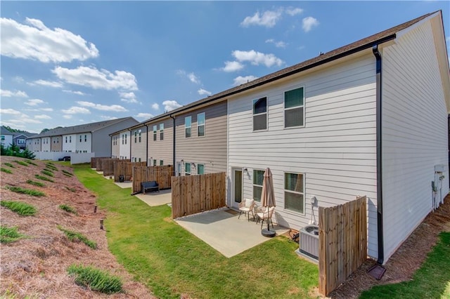 back of property featuring a yard, a residential view, fence, and a patio area