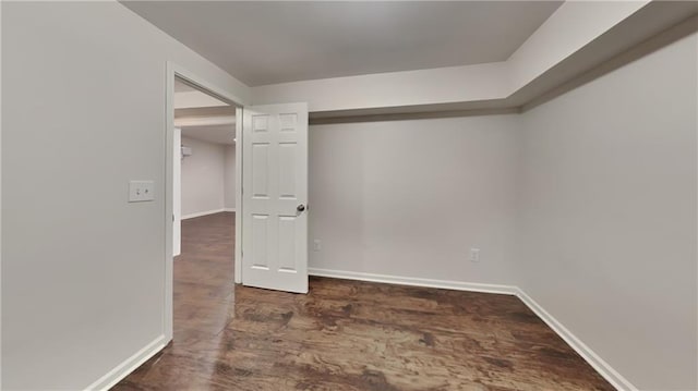 spare room with baseboards and wood finished floors