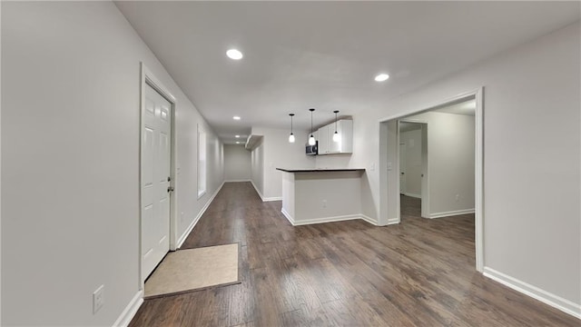 interior space featuring recessed lighting, baseboards, and dark wood-type flooring