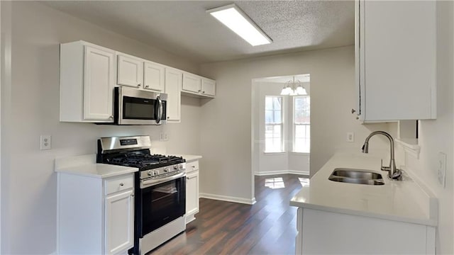 kitchen featuring dark wood finished floors, stainless steel appliances, light countertops, and a sink