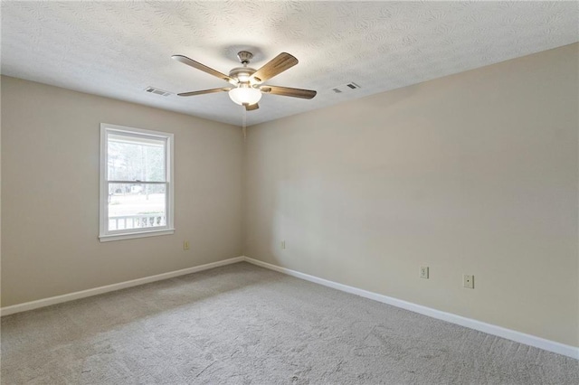 carpeted spare room featuring a textured ceiling and ceiling fan