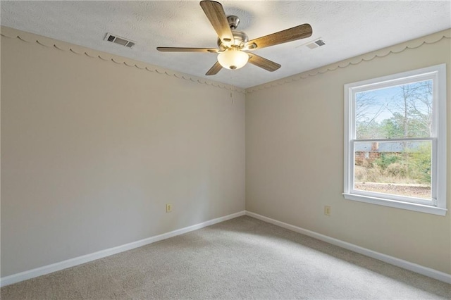 carpeted empty room featuring ceiling fan and a textured ceiling