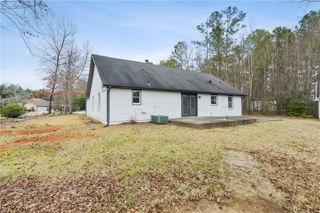 rear view of property with central air condition unit, a patio, and a lawn