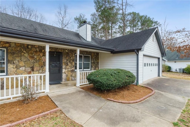 view of front of house with central AC, a garage, and covered porch