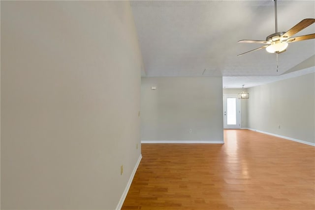 empty room with ceiling fan, lofted ceiling, and light hardwood / wood-style flooring