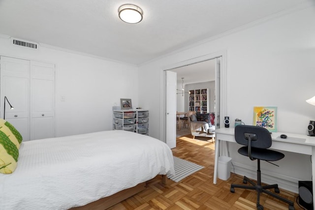 bedroom featuring a closet, crown molding, and parquet floors