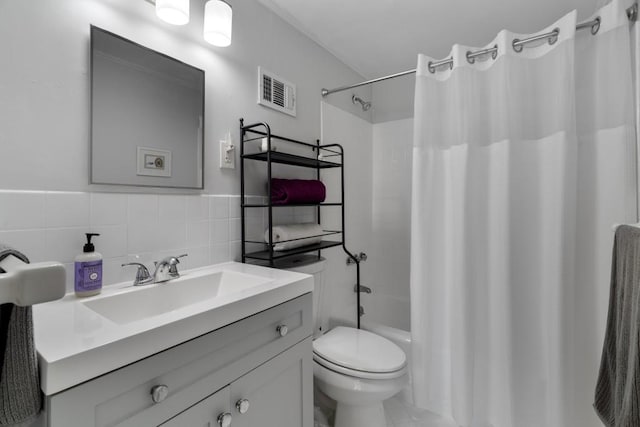 full bathroom featuring toilet, decorative backsplash, tile walls, shower / bath combo, and vanity