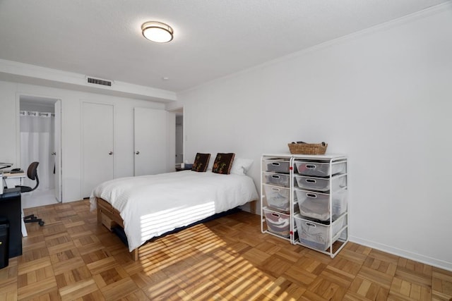 bedroom featuring a closet, parquet flooring, and crown molding