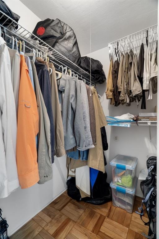 walk in closet featuring parquet flooring