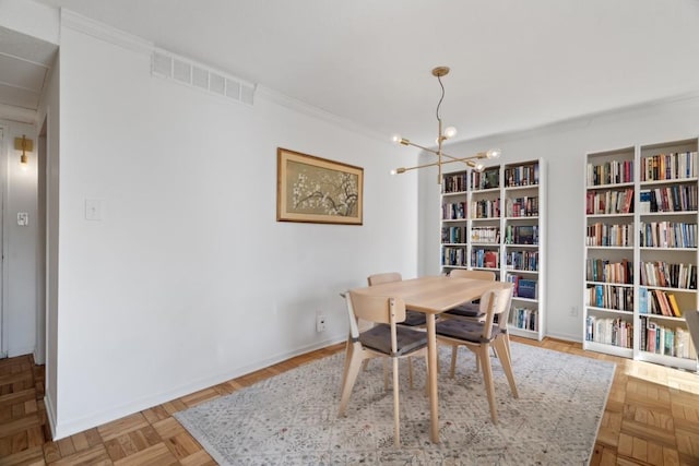 dining space with crown molding, light parquet floors, and a notable chandelier