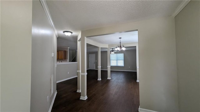 hallway with ornamental molding, dark hardwood / wood-style flooring, a notable chandelier, and a textured ceiling