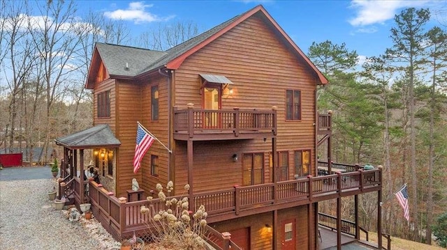 back of property featuring a garage and a balcony