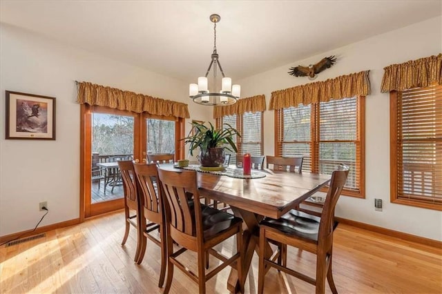 dining space with a chandelier and light hardwood / wood-style flooring