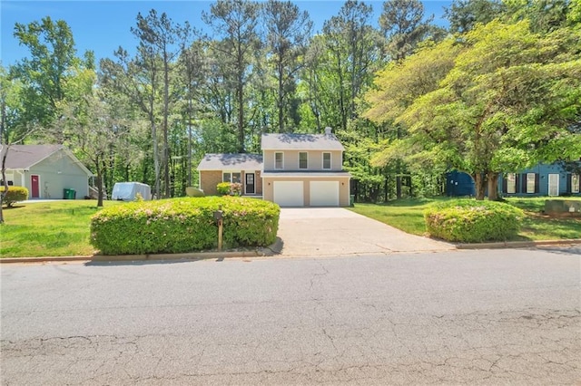 view of front facade featuring an attached garage, concrete driveway, and a front lawn