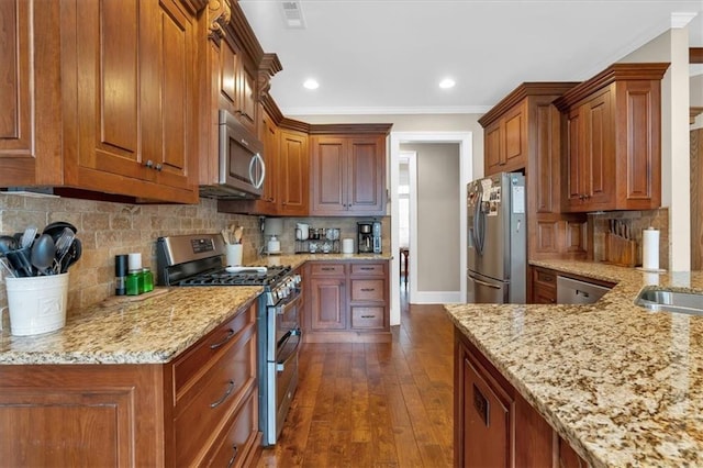 kitchen featuring ornamental molding, dark hardwood / wood-style floors, stainless steel appliances, light stone countertops, and decorative backsplash