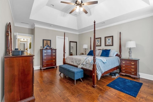 bedroom featuring crown molding, ceiling fan, dark hardwood / wood-style flooring, and a tray ceiling