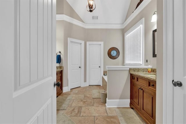 bathroom featuring a bathing tub, vaulted ceiling, ornamental molding, and vanity