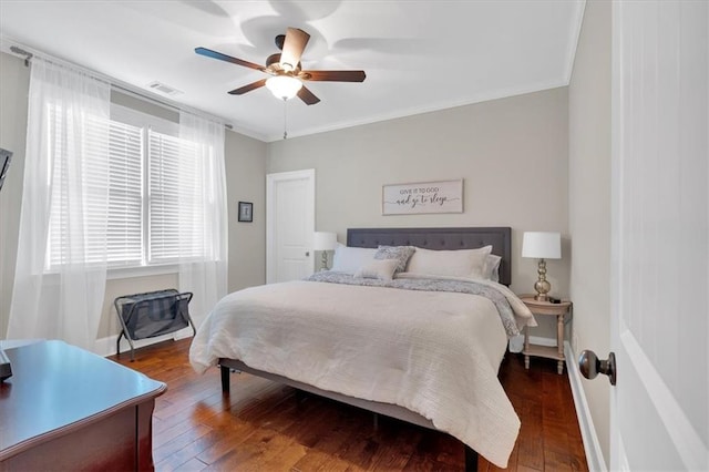 bedroom featuring crown molding, dark wood-type flooring, and ceiling fan