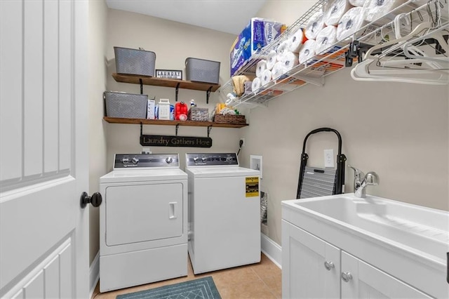 washroom featuring cabinets, separate washer and dryer, sink, and light tile patterned floors