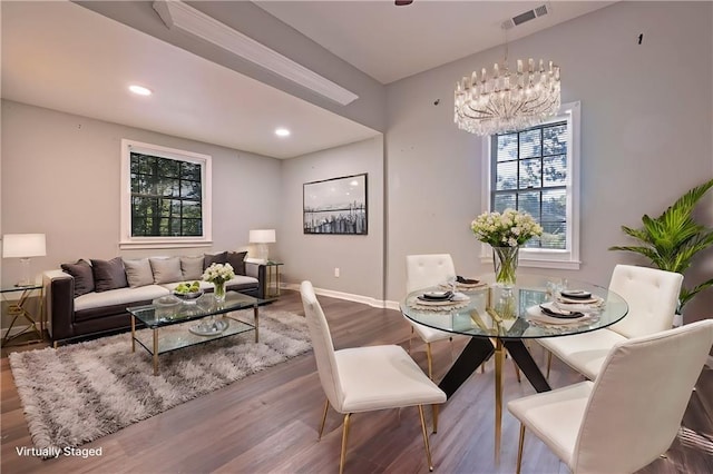 dining room featuring hardwood / wood-style floors and an inviting chandelier