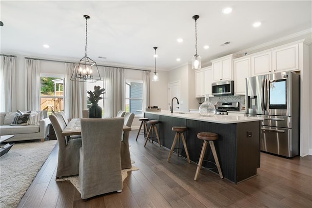 150 Azalea Xing, Dallas, GA 30132 - kitchen with appliances with stainless steel finishes, ornamental molding, a sink, a breakfast bar area, and white cabinets