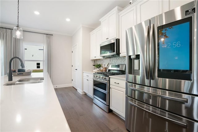 150 Azalea Xing, Dallas, GA 30132 - kitchen featuring appliances with stainless steel finishes, a sink, light countertops, ornamental molding, and dark wood finished floors
