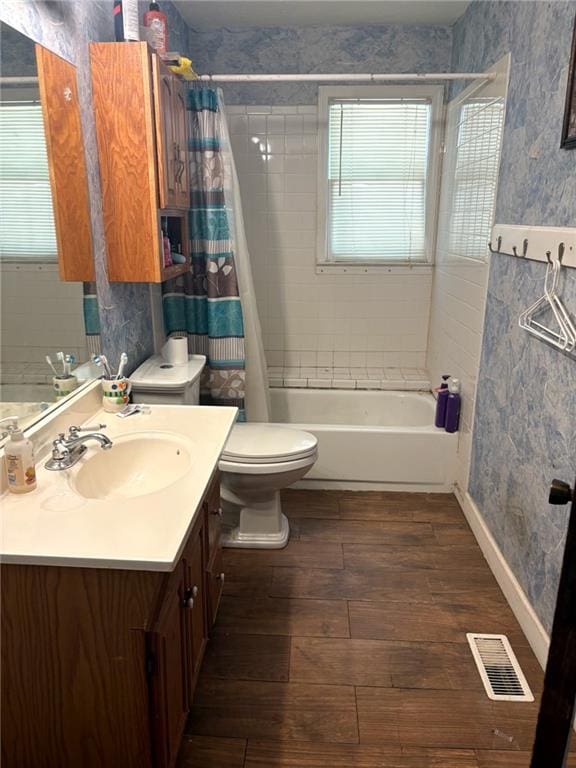 full bath featuring wood-type flooring, shower / tub combo with curtain, vanity, toilet, and wallpapered walls