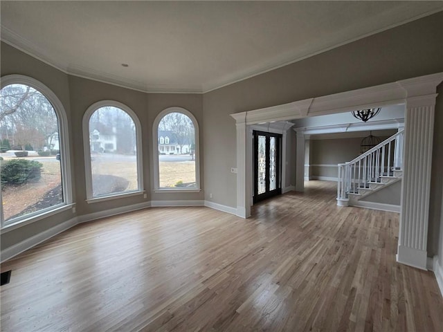 interior space with wood finished floors, a healthy amount of sunlight, baseboards, and stairs