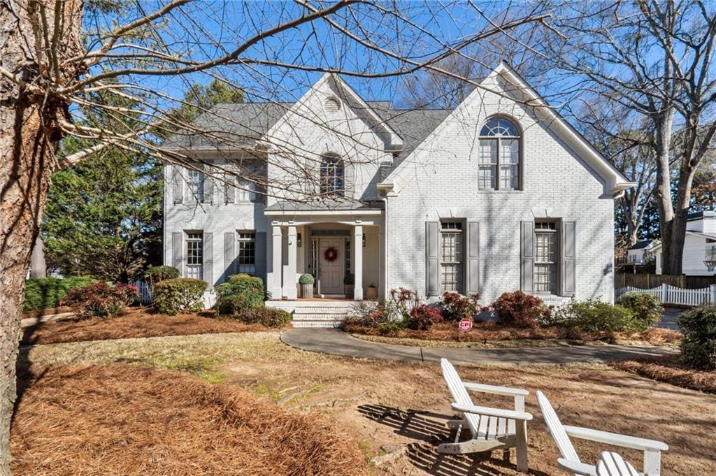 view of front of house with brick siding and fence