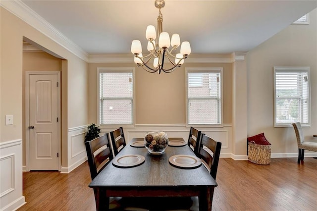 dining space featuring an inviting chandelier, wood-type flooring, and a healthy amount of sunlight