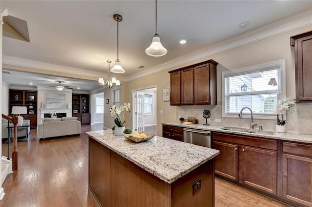 kitchen featuring dishwasher, sink, hanging light fixtures, a center island, and light hardwood / wood-style floors