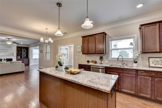 kitchen featuring hanging light fixtures, dishwasher, a center island, and sink