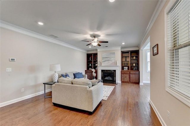 living room with crown molding, ceiling fan, and hardwood / wood-style flooring