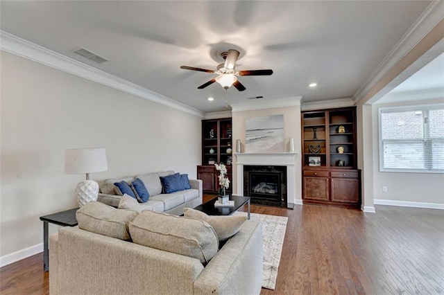 living room featuring crown molding, a fireplace, dark hardwood / wood-style floors, and ceiling fan