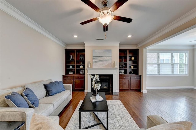 living room featuring ceiling fan, ornamental molding, and dark hardwood / wood-style flooring