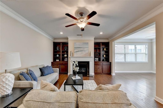 living room featuring dark wood-type flooring, ornamental molding, and ceiling fan